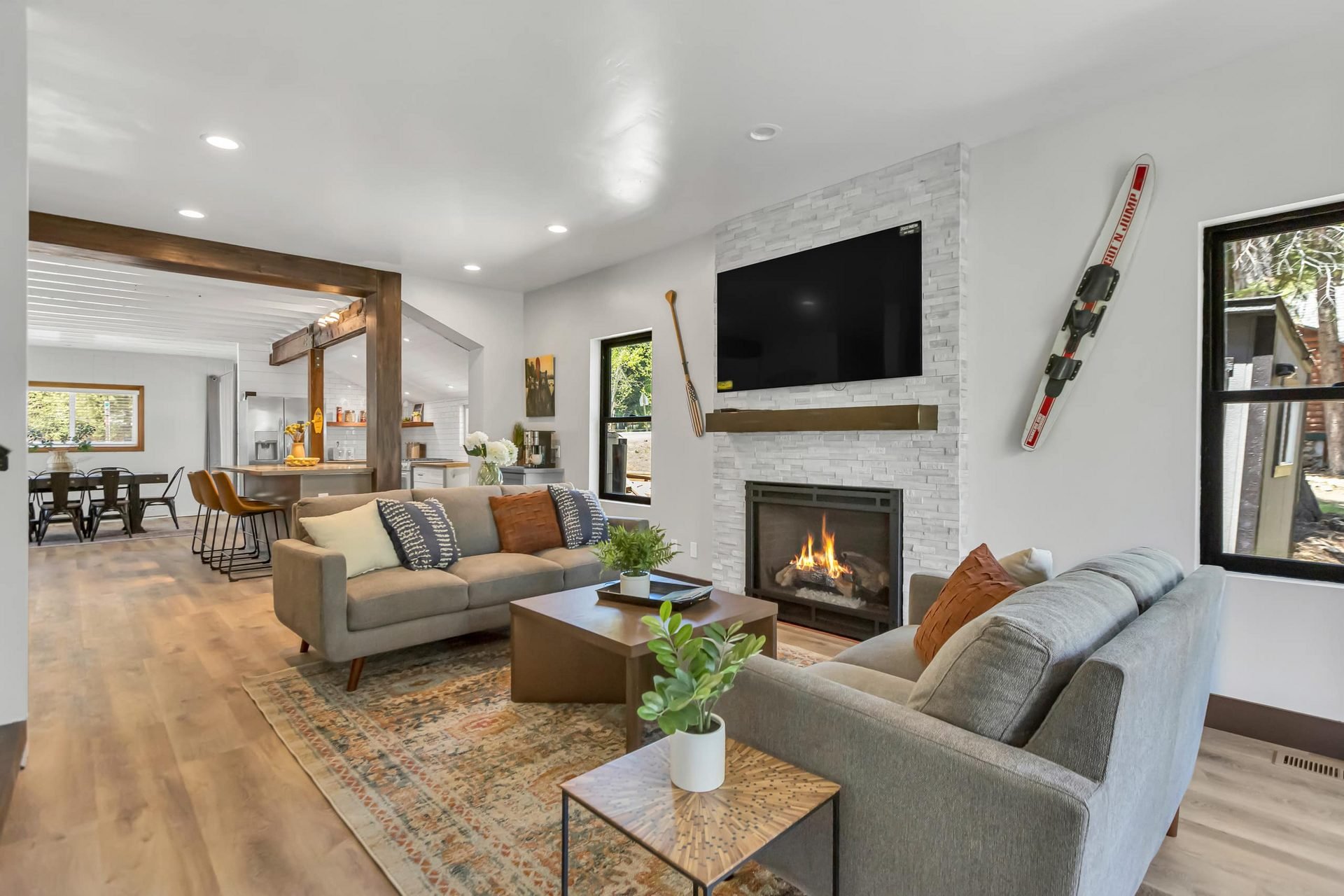 Bright cabin living room with sectional sofas, fireplace and television